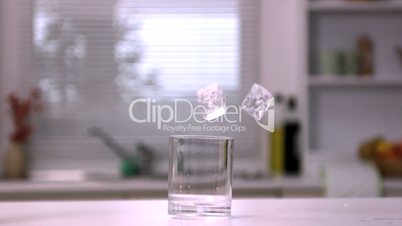 Two ice cubes falling in an empty glass