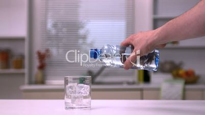 Hand pouring water into a glass