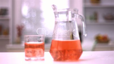Ice cubes spinning in a glass and in a jug with juice