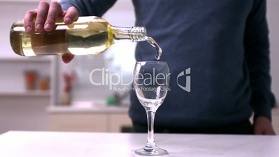 Man pouring white wine into a glass
