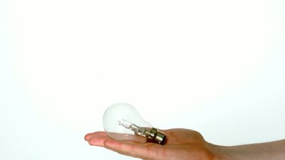 Mans hand tossing light bulb