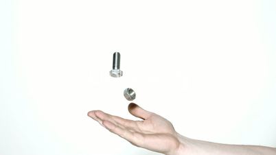 Mans hand tossing screw and bolt