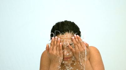 Happy woman splashing water on her face