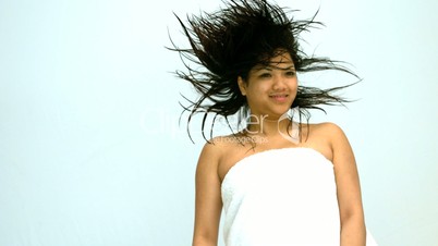 Smiling woman jumping in a white towel
