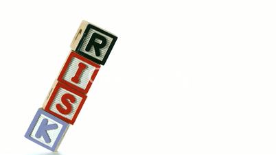 Blocks spelling Risk falling over on white background