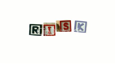 Risk spelled out in letter blocks falling in a row