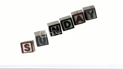 Sunday spelled out in letter blocks falling over