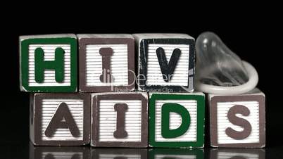 Condom falling on blocks spelling Aids and Hiv