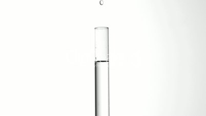 Drop of water falling into test tube of water