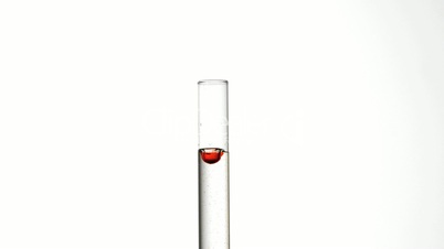 Drop of blood falling into test tube of water