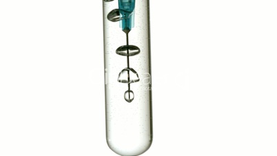 Syringe blowing bubbles in test tube of water