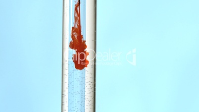 Syringe injecting blood in test tube of water