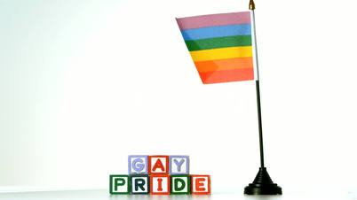 Rainbow flag blowing in the breeze beside gay pride blocks