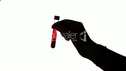 Hand shaking test tube of blood on white background