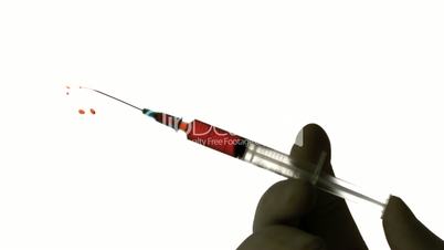 Hand injecting blood from syringe