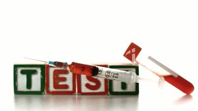 Syringe falling in front of test tube and blocks spelling test