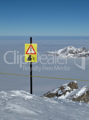 Danger sign "cliffs", sea of fog and mountains, Titlis