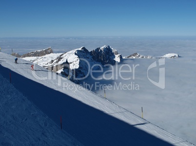 Ski slopes on the Titlis, mountains and sea of fog , skier