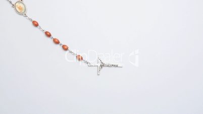 Crucifix of beads on white surface