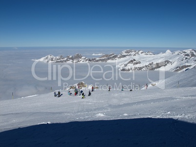 Skier on top of the Titlis, sea of fog and mountains