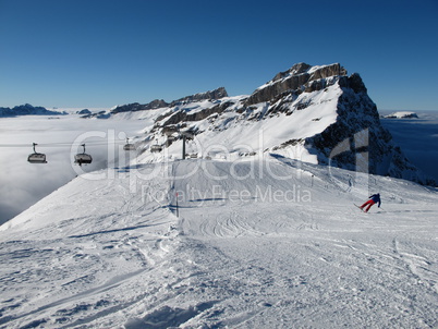 Mountain, sea of fog and staggering skier, Titlis region