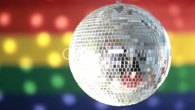 Disco ball spinning against rainbow flag