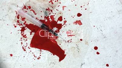 Syringes falling on bloody surface