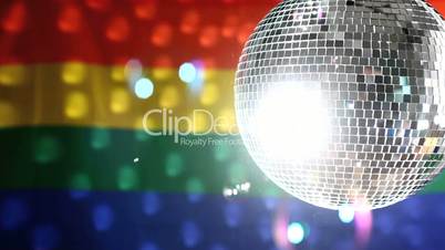 Disco ball revolving against gay pride flag