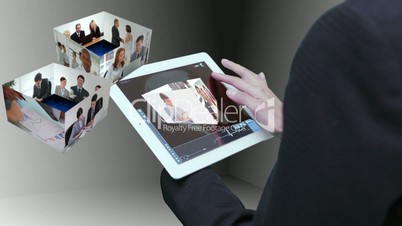 Businesswoman using tablet to view montage of business people at work