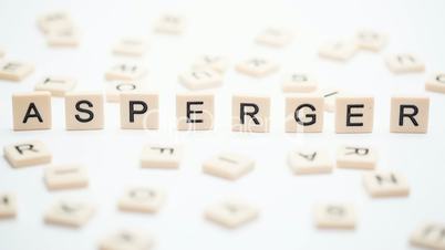 Asperger spelled out in plastic letter pieces falling down