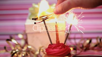 Sparklers on a birthday cupcake with gift