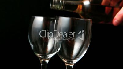 Two glasses of white wine being poured