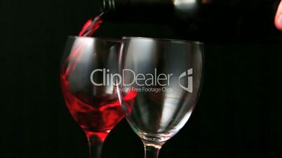 Two glasses of red wine being poured