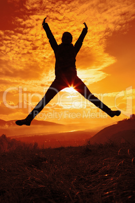 Happy young woman jumping at the sunset