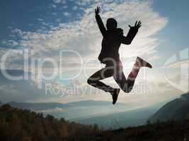 Happy young woman jumping at the sunset