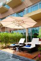 Sunbeds and umbrella near building of luxury hotel, Dubai, UAE