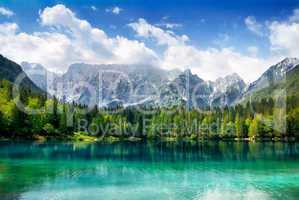 Türkisfarbener See mit Wald und Bergen