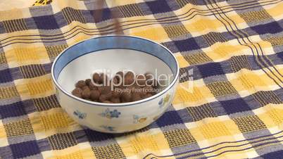 Chocolate cereal flakes pouring into bowl
