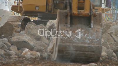 Excavator moving large stones