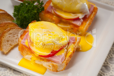 eggs benedict on bread with tomato and ham