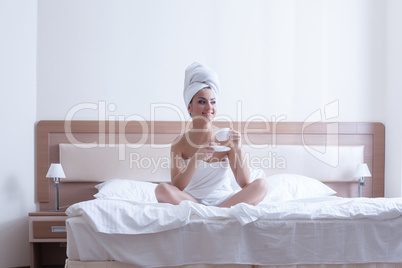 Young brunette woman relax with coffee in bed