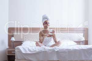 Young brunette woman relax with coffee in bed