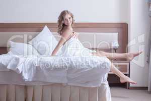 Pretty woman in rose lingerie play with pillows
