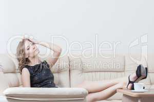Beautiful young woman sitting on sofa