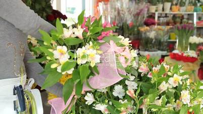 Woman Arranging Flowers In Flower Retail Shop