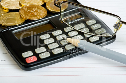 Calculator, glasses, coins and pencil