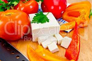 Feta cheese with vegetables on the board