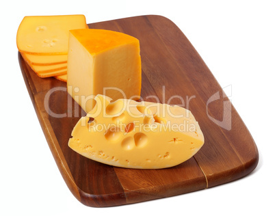 Cheeses on wooden kitchen board