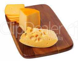 Cheeses on wooden kitchen board