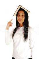 School girl with book on head.